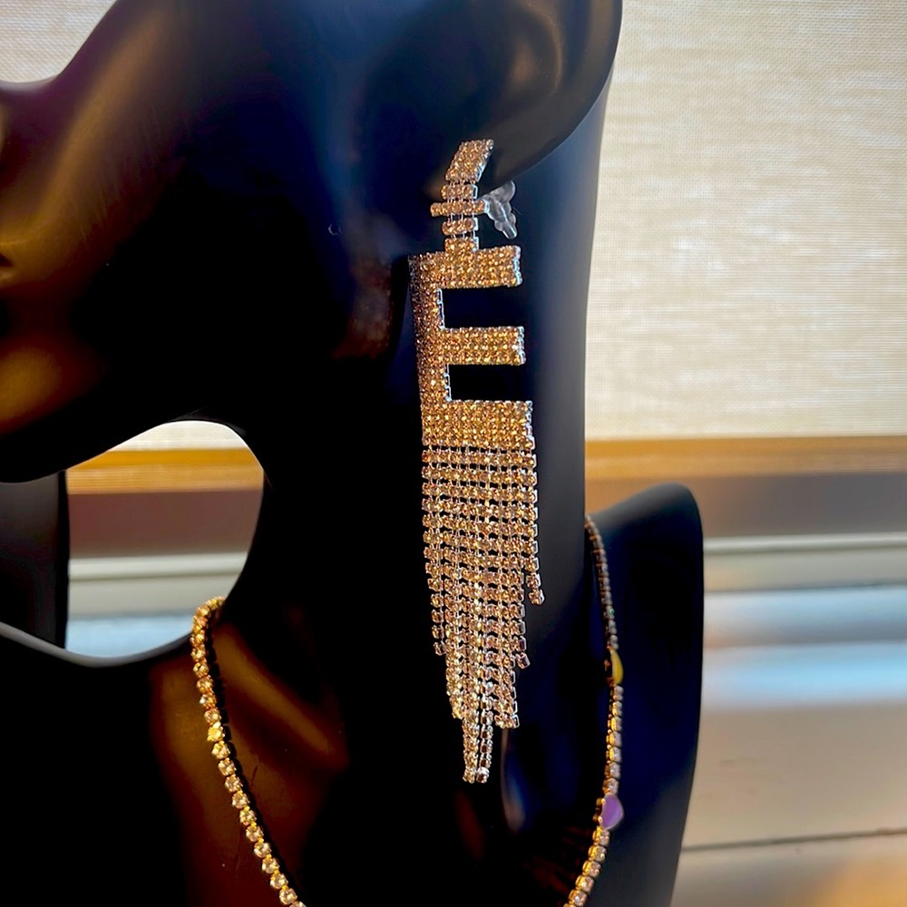 Rhinestone drip “e” earrings.